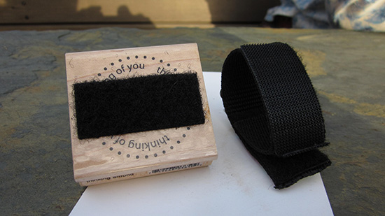Crafty paw, a velcro bracelet, and a velcro strip on a wood-mounted stamp